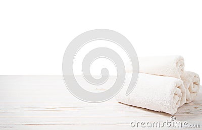 Rolled white towels on white wooden table isolated on white background. Copy space and top view. Bathroom objects for shower body Stock Photo