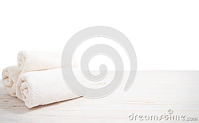 Rolled white towels on white wooden table isolated on white background. Copy space and top view. Bathroom objects for shower body Stock Photo