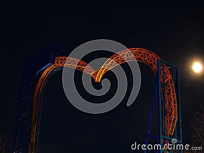 Roller coaster inverted tracks by night and moon shining Stock Photo