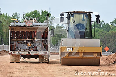 Roller machine gets refueled by fluids truck Editorial Stock Photo