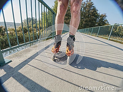 Roller skater ride in park. Boy legs in in-line hard shell boots blades. Editorial Stock Photo