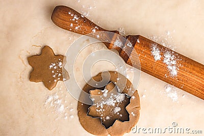Rolling pin, star shaped metal baking dish, ginger dough on craft paper, process of making homemade cakes Stock Photo