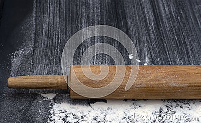 Rolling pin on textured black bord with traces Wheat Flour. Free space for text Stock Photo