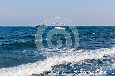 Seascape with military ship and motor yacht Stock Photo