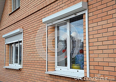 Rolling shutters house windows protection. Brick house with metal roller shutters on the windows Stock Photo