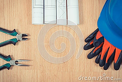 Rolls of electrical drawings, protective helmet with gloves and work tools, copy space for text on boards Stock Photo