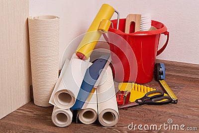 Rolls of wallpapers and various tools for wallpapering. Stock Photo