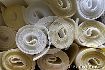 Rolls white and yellow foam rubber building material texture. Polystyrene sealing foam sheet surface background Stock Photo