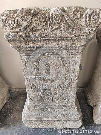 Roman pillar with latin inscriptions and decorations Stock Photo