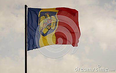 Romanian flag with coat of arms with gray background with clouds Stock Photo