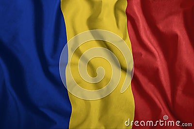 The Romanian flag is flying in the wind. Colorful, national flag of Romania. Patriotism, a patriotic symbol. Stock Photo