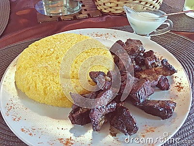 In Romanian, Pastrama de oaie smoked sheep meat and then barbecue and in Romanian also, mamaliga polenta in a restaurant in Ar Stock Photo