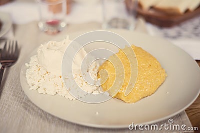Romanian polenta dish with cheese and sour cream Stock Photo