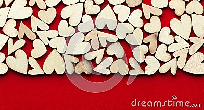 Romantic background of dozens of tiny wooden hearts on a red card. For love, romance, or Valentine`s Day Stock Photo