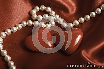 Beautiful pearls jewerly and two hearts like romantic background Stock Photo