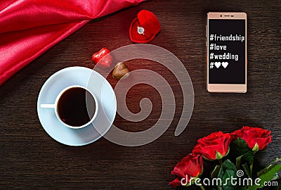 Romantic background with wedding ring, rose flowers, smartphone, cup of coffee and chocolate candy Stock Photo