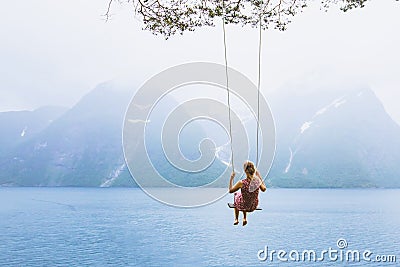 Girl on swing in Norway, happy dreamer, inspiration background Stock Photo