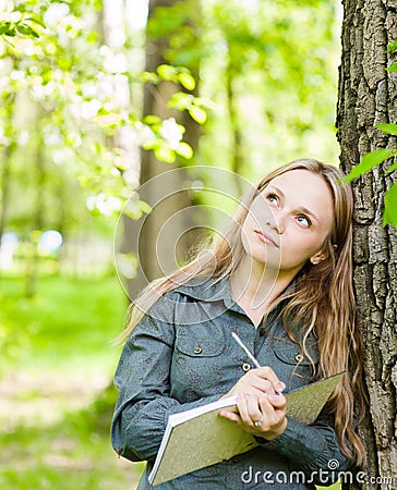 Romantic beautiful girl writes love poems on nature Stock Photo