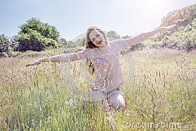 Romantic beautiful teenage girl with arms stretched like flying Stock Photo