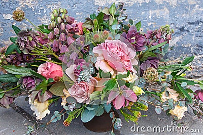 Romantic bouquet of beautiful flowers near old grunge wall Stock Photo