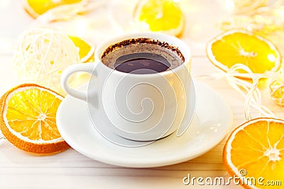 Romantic breakfast. A cup of black coffee with chocolate on a background of glowing lanterns. Stock Photo