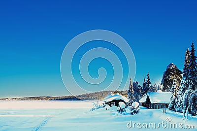 Romantic cabin by a frozen remote lake covered with snow Stock Photo