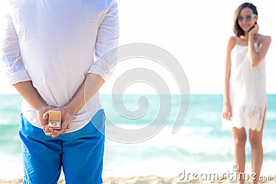 Romantic concept with man holding white ring making marriage proposal in the beach. Asian couple lover honeymoon at luxury reso Stock Photo