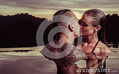 Romantic couple alone in infinity swimming pool Stock Photo
