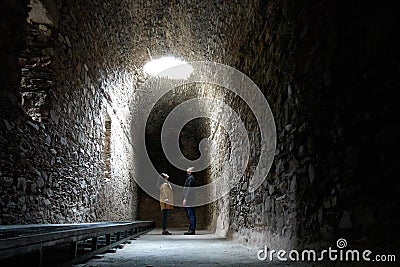 Romantic couple on a dark ruin antique temple arab muslim church tunnel room with a hole where light comes through Editorial Stock Photo