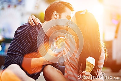 Romantic couple kissing while holding ice cream Stock Photo