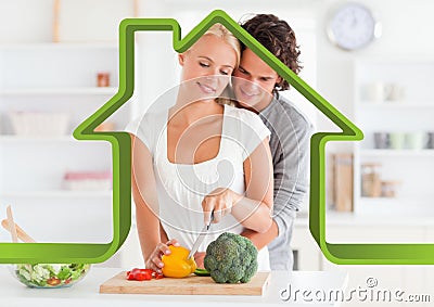 Romantic couple in kitchen against house outline in background Stock Photo