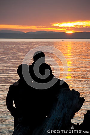 Romantic Couple Looking at Sunset Over Water Stock Photo