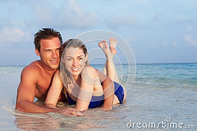 Romantic Couple Lying In Sea On Tropical Beach Holiday Stock Photo