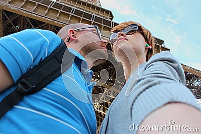 Romantic couple making selfie in front of Eiffel Tower while traveling in Paris, France. Students enjoy their vacation Stock Photo