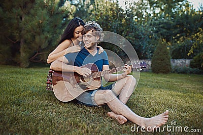 Romantic couple sitting on the grass in the garden Stock Photo