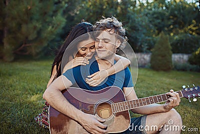 Romantic couple sitting on the grass in the garden Stock Photo