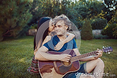 Romantic couple sitting on the grass in the garden Stock Photo