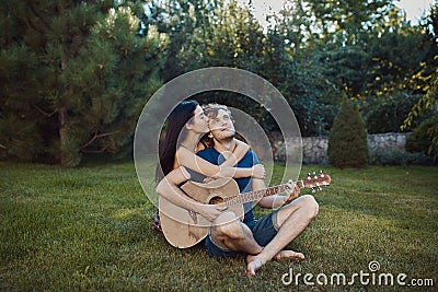 Romantic couple sitting on the grass in the garden Stock Photo