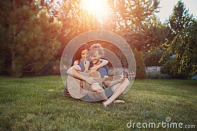 Romantic couple sitting on the grass in the garden Stock Photo