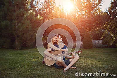 Romantic couple sitting on the grass in the garden Stock Photo