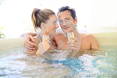 Romantic couple spending good time drinking champagne in jacuzzi Stock Photo