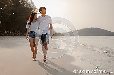 Romantic couple walking holding hands each other while at beach at sunrise, plan life insurance at future concept. Stock Photo