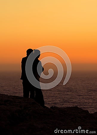 Romantic couple watching sunset Stock Photo