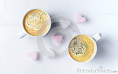 Romantic desk top with two cups of coffee and pink heart shaped marshmallows. Top view. Stock Photo
