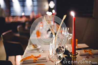 Romantic dinner setup, red decoration with candle light in a luxury gastro pub restaurant. Selective focus. For celebrations and Stock Photo
