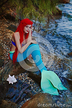 Romantic dreamer girl in mermaid costume on sea side Stock Photo