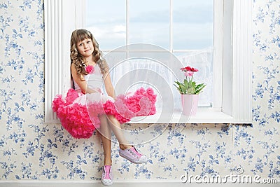 Romantic dreaming young girl sitting on windowsill Stock Photo