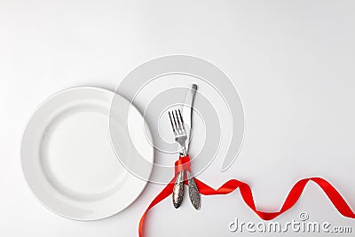 Romantic festive table setting on white background. Valentines day card template. Red ribbon, plate, silverware, vintage Stock Photo