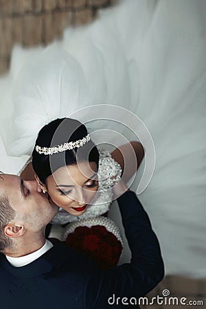 Romantic groom kissing brunette bride on the neck, shot from above closeup Stock Photo