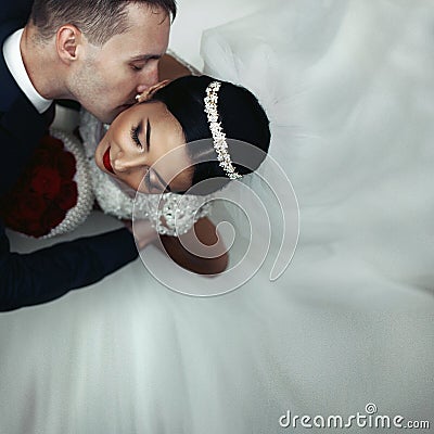 Romantic groom kissing brunette bride on the neck, shot from above closeup Stock Photo